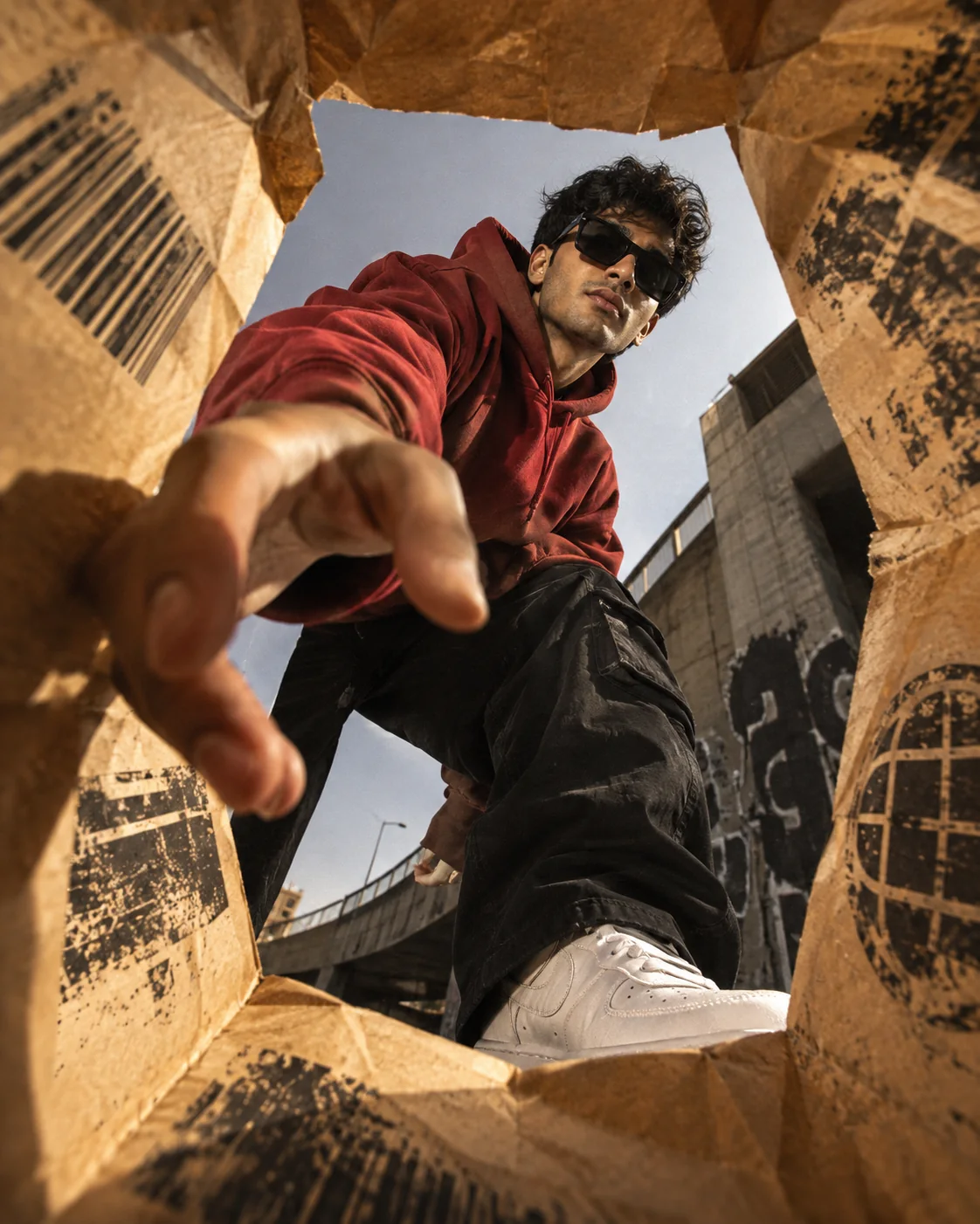 Model wearing an ANDAZZ red hoodie and black cargo pants