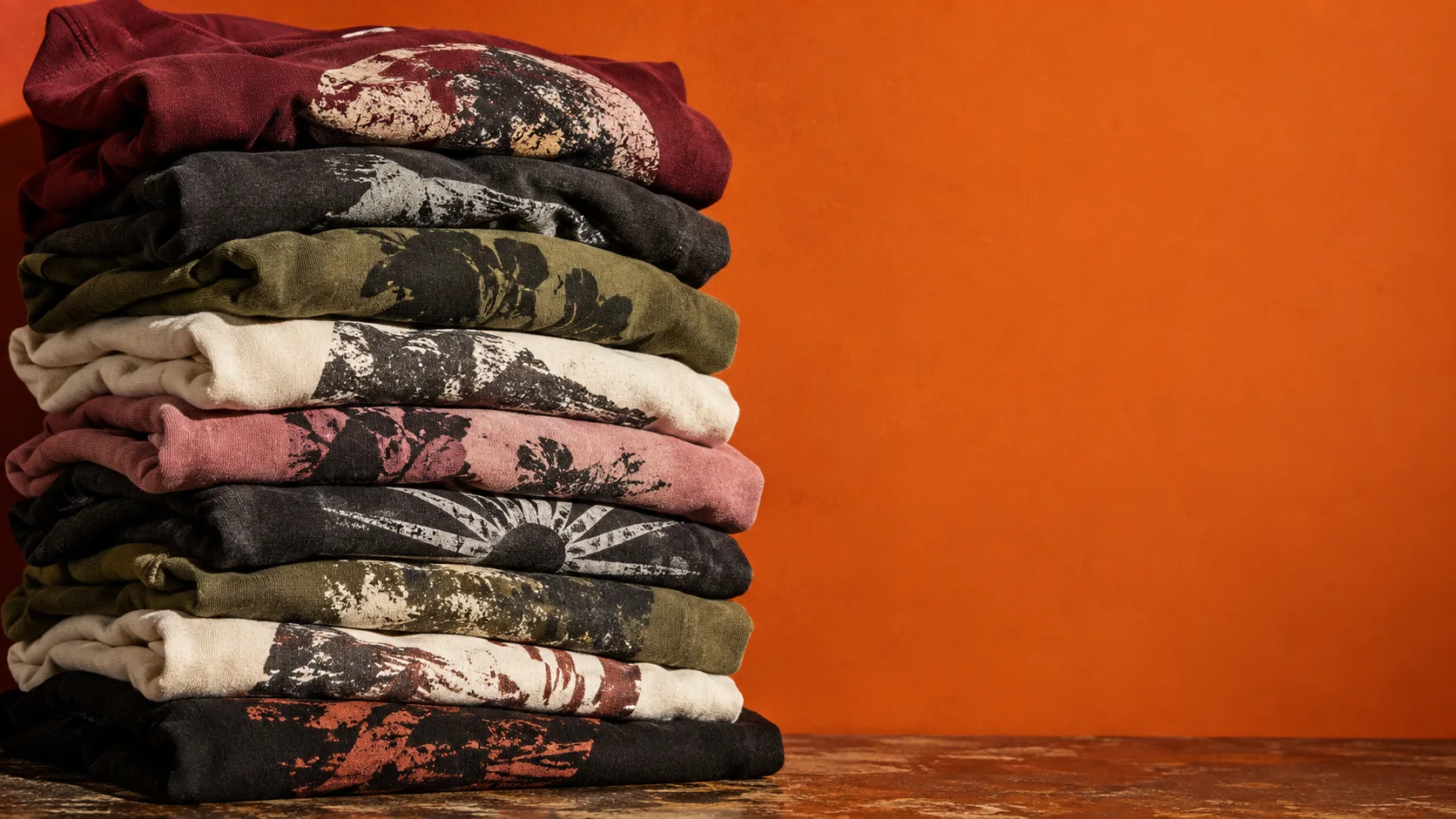 A stack of folded ANDAZZ graphic streetwear